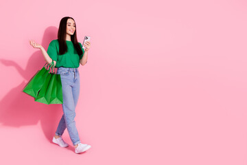 Full length photo of adorable lovely girl wear green t-shirt making orders modern device empty space isolated pink color background