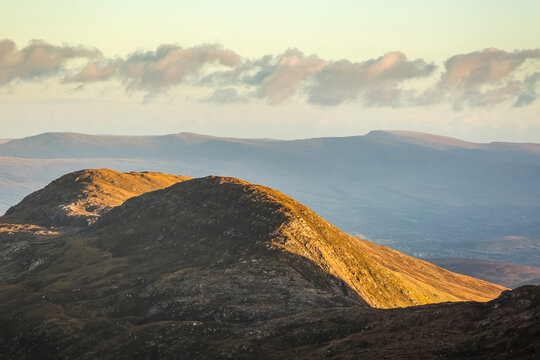 Last of the sun rays hitting the lower hills in the Kerry mountains; MacGillycuddy's Reeks, County Kerry, Ireland