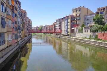 Naklejka premium Girona, Spain - 23 July, 2024: Colored houses on River Onyar, Girona, Catalonia