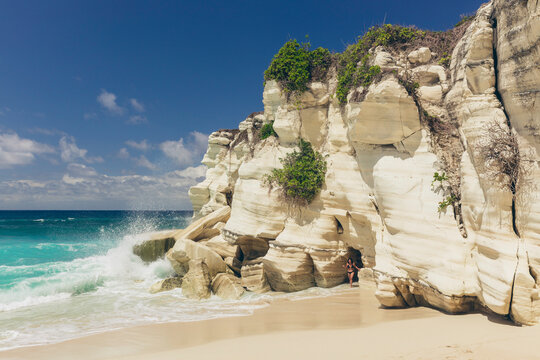 Pristine turquoise ocean water and white sand beach with rugged white cliffs on an island in the Indian Ocean, Southeast Asia; Patiala Bawa, Lamboya, West Sumba Regency, East Nusa Tenggara, Indonesia