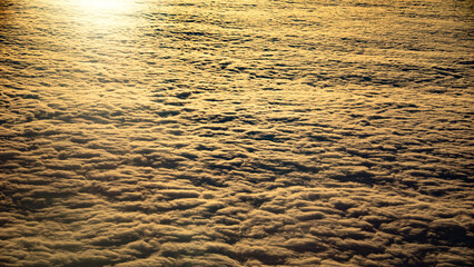 The sky glows with a golden sunset, casting a warm light on clouds, creating a picturesque scene