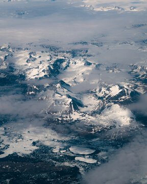 An aerial view above the snowy mountains of Greenland