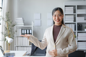 Confident, smiling businesswoman in a modern office presents a promising opportunity with a...