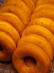 A close-up of a stack of freshly baked glazed donuts