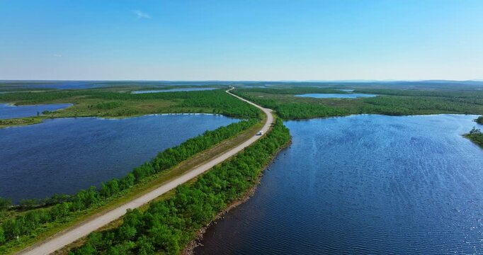 Aerial view of a RV driving in middle of lakes in Kevoi nature, summer in Lapland