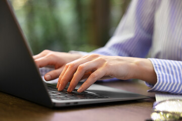 Businesswoman working with laptop at table outdoors, closeup. Remote job