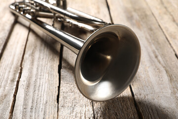 One trumpet on wooden table, closeup. Musical instrument