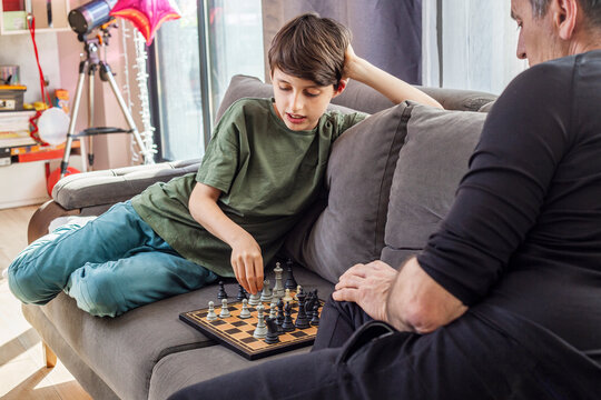 Father and son playing chess at home