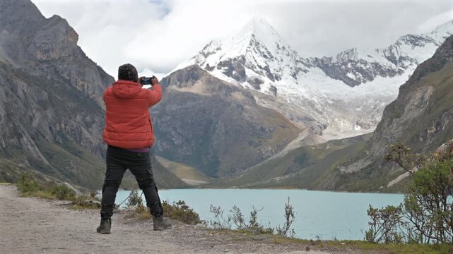 Male hiker at Paron lake taking picture with smartphone.