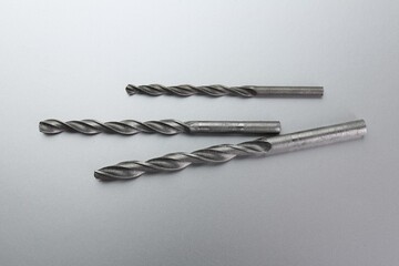 Different drill bits on light grey background