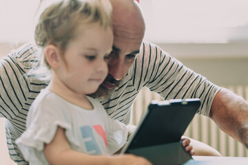 Fototapeta premium Young family using digital tablet at home