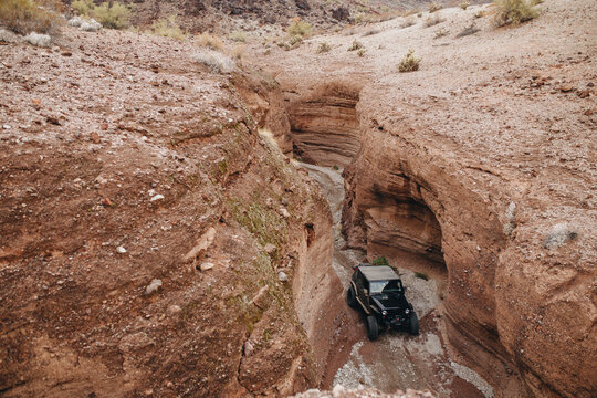 Off-road vehicle navigating a narrow canyon.