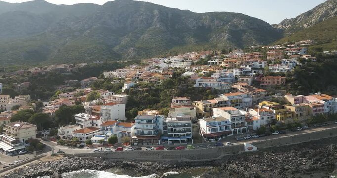 Cala Gonone, Gulf of Orosei, Sardinia, Italy - Vibrant Houses Overlooking the Beach - Orbit Drone Shot