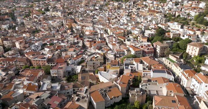 Crowded Mountain Village Of Dorgali On Sunny Day In Sardinia, Italy. aerial pullback, tilt-up shot