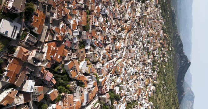 Dorgali Village Skyline And Supramonte Mountains In Sardinia, Italy. Vertical Aerial Shot.