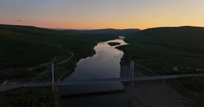 Aerial view away from the Sami Bridge over the Tenojoki river, dawn in Utsjoki, Finland