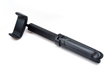 Universal tripod and selfie stick isolated on white background. Black plastic portable phone stick