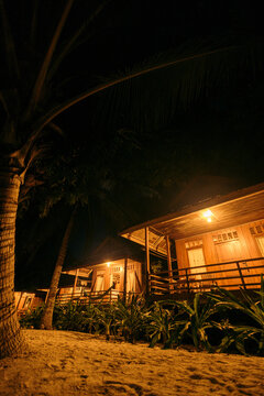 Beachside accommodations illuminated at night on Bolilango Island in the Togian Islands of Indonesia; Bolilanga Island, Togean Islands, Katupat, Kabupaten Tojo Una-Una, Sulawesi Tengah, Indonesia