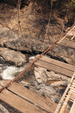 Rickety suspension bridge and waterfall below on the island of Don Khon, Laos; Don Khon, Champasak Province, Laos