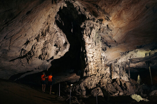Tourists wearing lifejackets stand in the dark Kong Lor Cave in Phu Hin Bun National Park, Laos; Khammouane Province, Laos