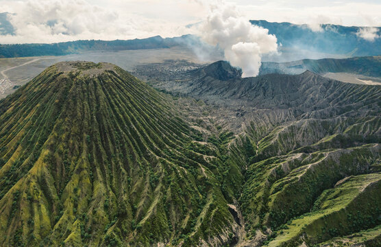 Mount Batok in the foreground and steam from the crater of Mount Bromo in Bromo Tengger Semeru National Park in East Java, Indonesia; Ranupani, East Java, Indonesia