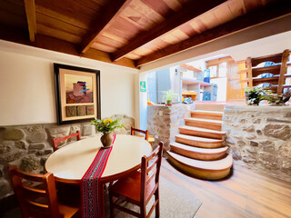 Interior view of home in Cusco, Peru. The stairs are rounded, the walls are brick, and the ceiling...
