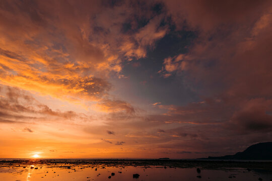 Dutungan Island with a warm sunset over the ocean, Sulawesi Selatan, Indonesia; Dutungan Island, Kecamatan Mallusetasi, Kabupaten Barru, Sulawesi Selatan, Indonesia