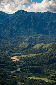 River winding through a lush mountainous landscape with the remote village of Lembah Ollon; Lumbah Ollon, Bonggakaradeng, Tana Toraja Regency, South Sulawesi, Indonesia