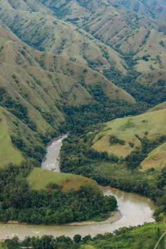 River winding through a lush mountainous landscape with the remote village of Lembah Ollon; Lumbah Ollon, Bonggakaradeng, Tana Toraja Regency, South Sulawesi, Indonesia