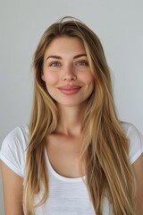 Naklejka premium portrait photo of a smiling young woman with long hair wearing a tight white shirt