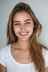 Naklejka premium portrait photo of a smiling young woman with long hair wearing a tight white shirt