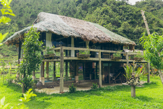 Two story house with thatch roof in the Vietnam countryside; Ngoc Chien, Muong La District, Son La, Vietnam