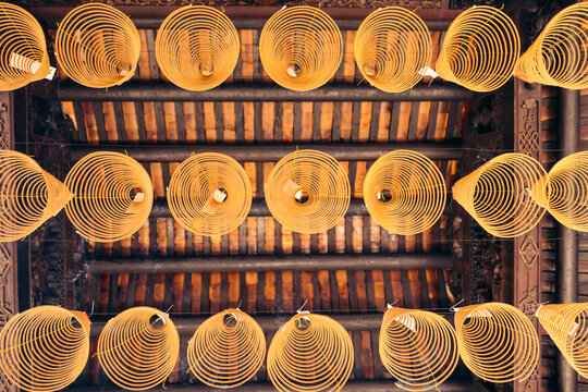 Spiral cones hanging in a row inside a Buddhist temple, Ba Thien Hau Temple; Ho Chi Minh City, Vietnam