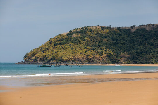 Beautiful beach with golden sand and coastline with boats moored near the shore in the Con Dao archipelago, South China Sea, Vietnam; Con Dao, Ba Rịa - Vung Tau, Vietnam