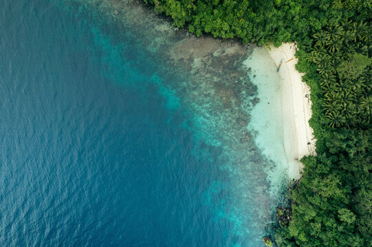 Aerial view from directly above a white sand beach and clear turquoise ocean water at Pasir Putih Beach along the coast of Central Sulawesi, Indonesia; Banggai Laut, Central Sulawesi, Indonesia