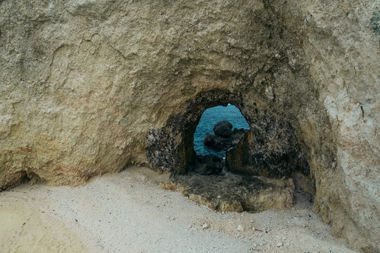 Natural arch and white sand beach along a coastline in the Molucca Sea, in Central Sulawesi, Indonesia; Tanjung Gundul Pasir Putih, Banggai Islands Regency, Central Sulawesi, Indonesia