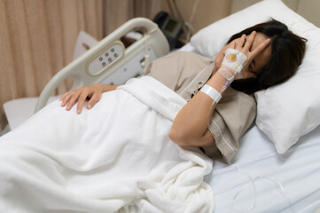 Asian woman is sick and is being treated at the hospital,Waiting for the doctor to give intravenous medication,A nurse came to take my temperature and measure my blood pressure.