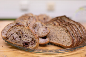 A plate of freshly sliced bread with olives and walnuts