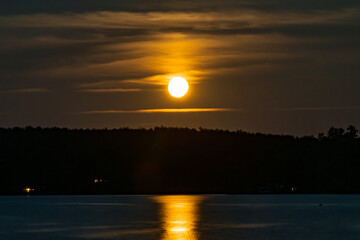 Full moon rising over a harbor