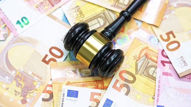 Gavel on stack of euros spinning on table
