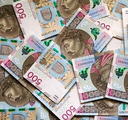 Banknoty o nominale 500 zł porozrzucane na ziemi. Liczne banknoty widoczne z bliskiej odległości. Polska waluta fiducjarna o wysokim nominale. Pieniądze używane w Rzeczpospolitej.