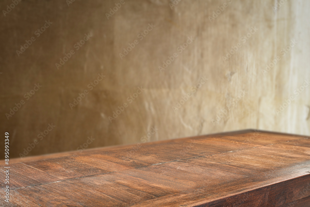 Wall mural dark wooden table top with empty copy space and gold structured textured wall backround.