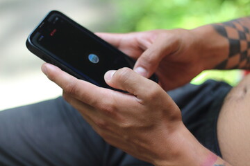 Tattooed Male Hands Using Tinder on Phone