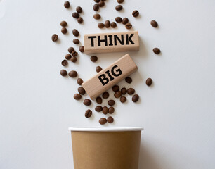 Think big symbol. Wooden blocks with words Think big. Beautiful white background with coffee cup....