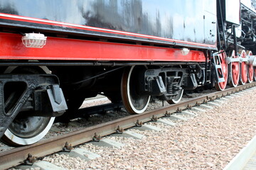 Naklejka premium Iron wheels of a steam locomotive on rails.
