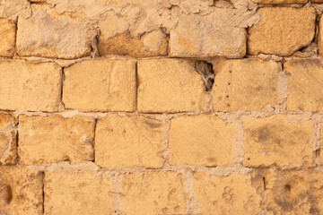 A weathered brick wall with missing mortar
