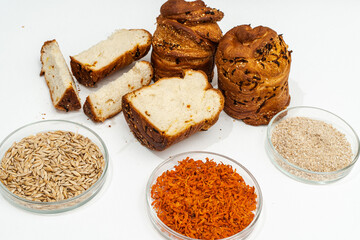 Sliced brioche with carrots on a white table with glass bowls with ingredients