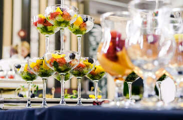 Glasses with Vegetable Salad on Buffet Table. Focus on glasses filled with vegetable salad, elegantly arranged on a buffet table. Original presentation of vegetable salad. Horizontal photo.