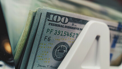 Money counting machine counts hundred dollar bank notes for currency exchange, budget calculation...