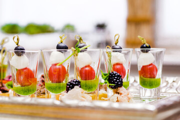 Caprese Appetizers in Shot Glasses. Caprese appetizers in shot glasses, with mozzarella, cherry tomatoes, and olives, beautifully arranged on a tray.